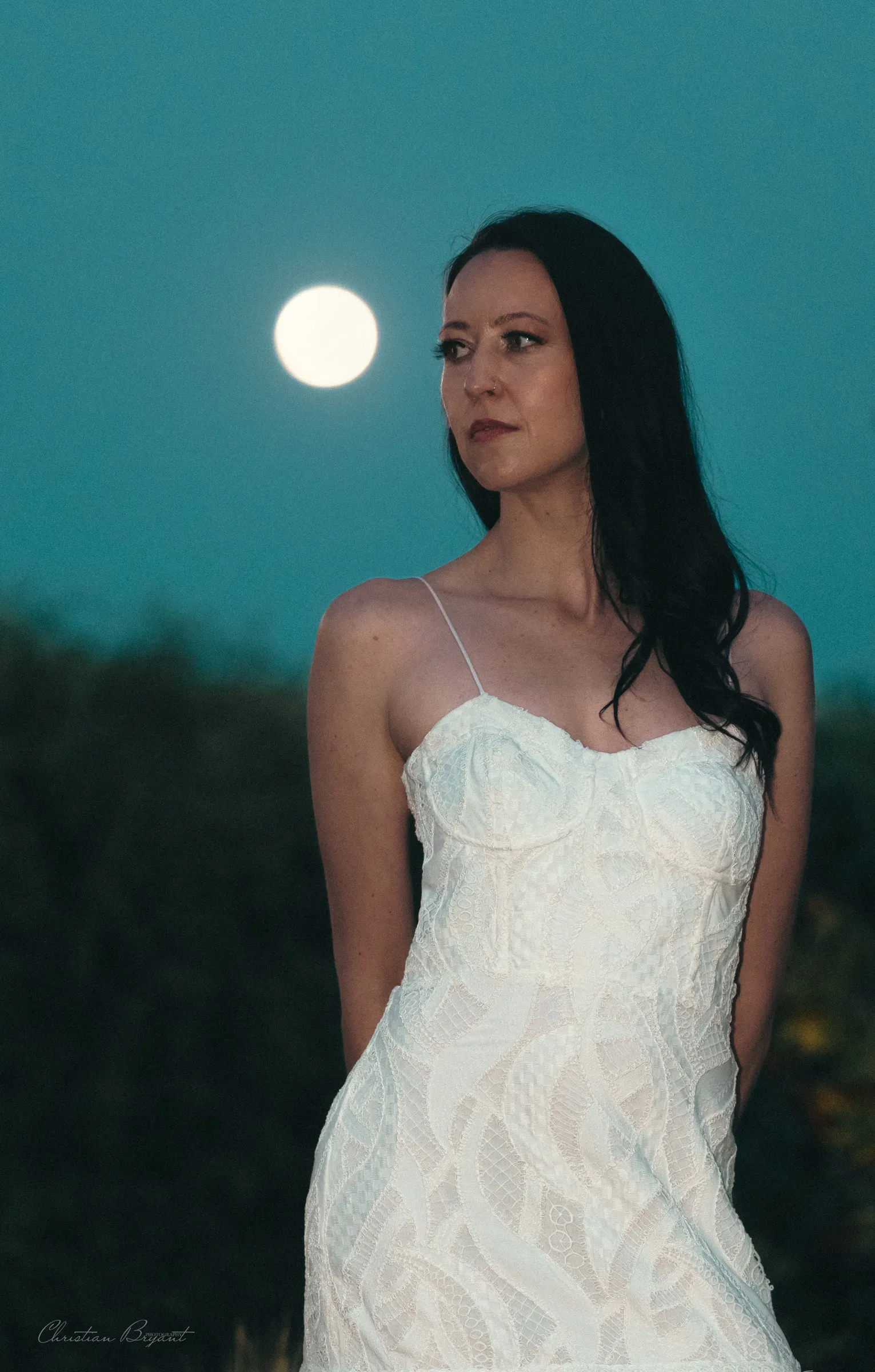 Bride photographed against a full moon at dusk