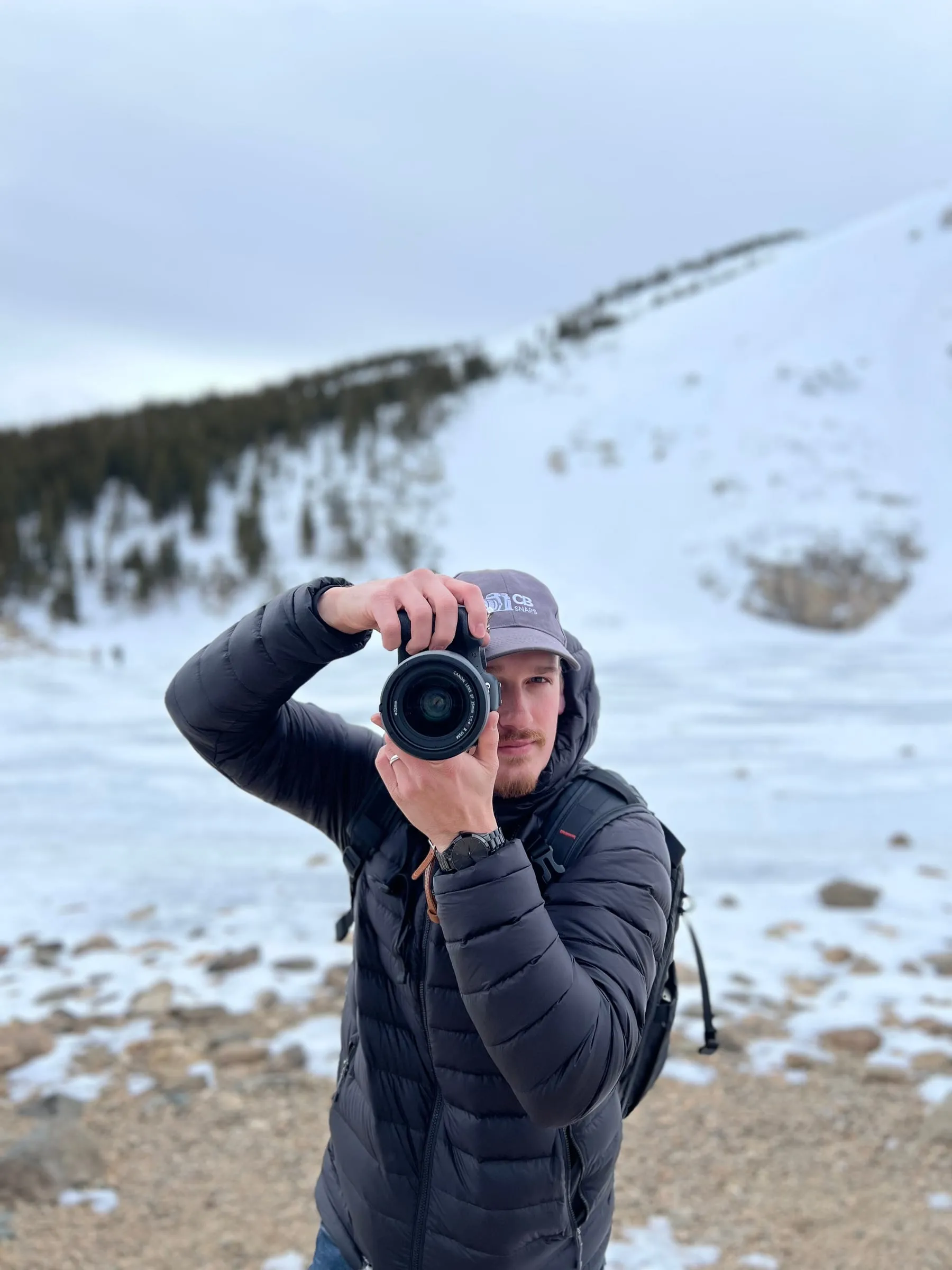 Christian in the snow, raising his camera toward the viewer