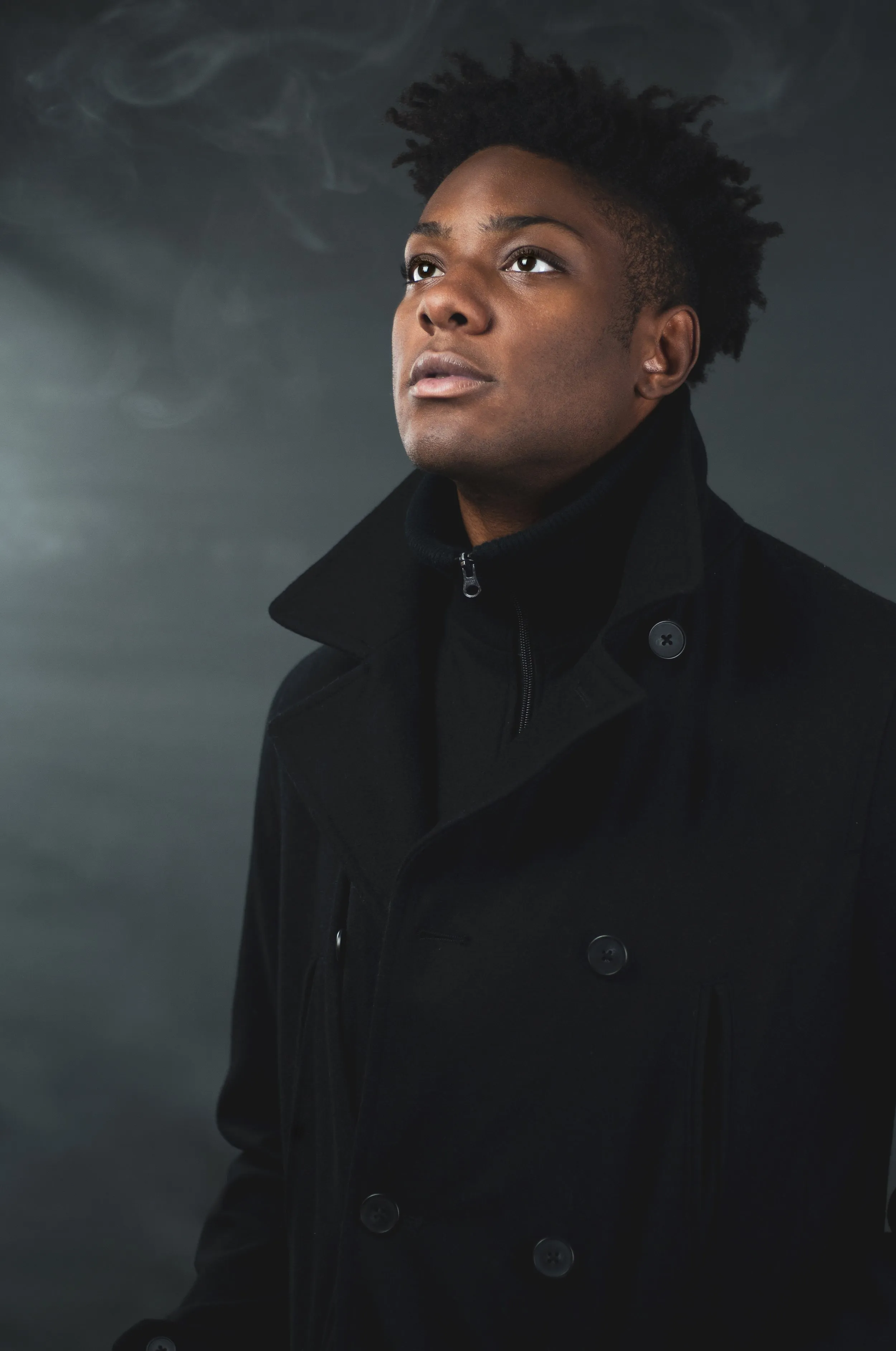 Studio portrait lit against a dark backdrop